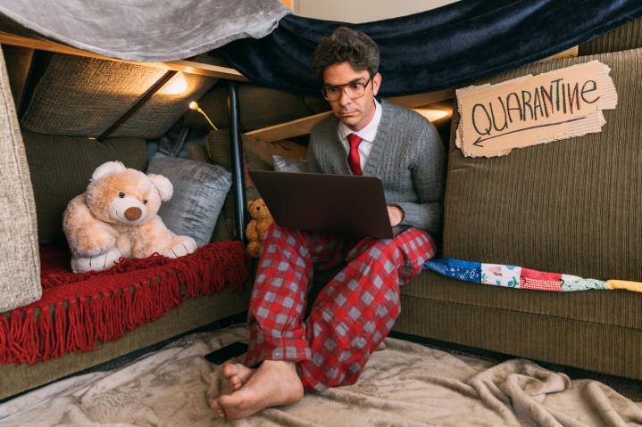 A man sitting on a sofa shelter with the laptop